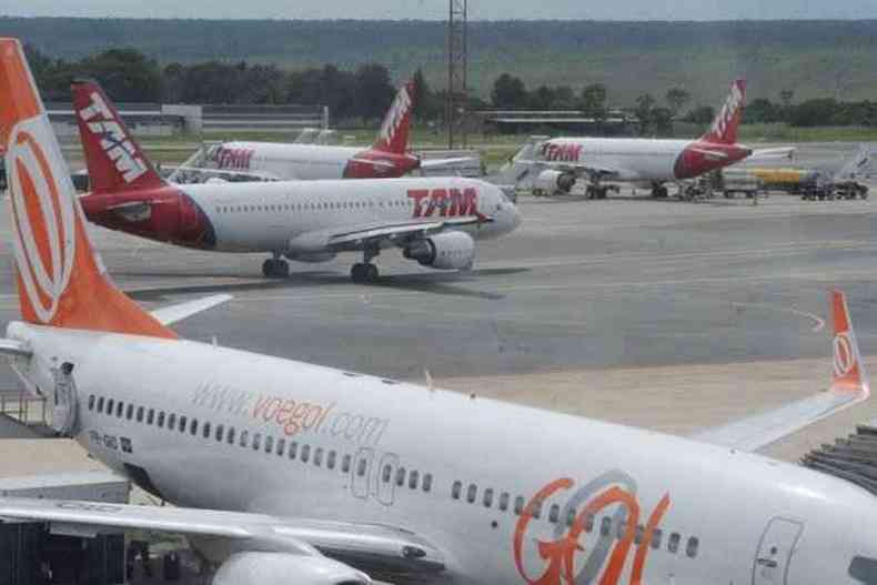Aviões da Latam e Gol estacionados em pátio de aeroporto 