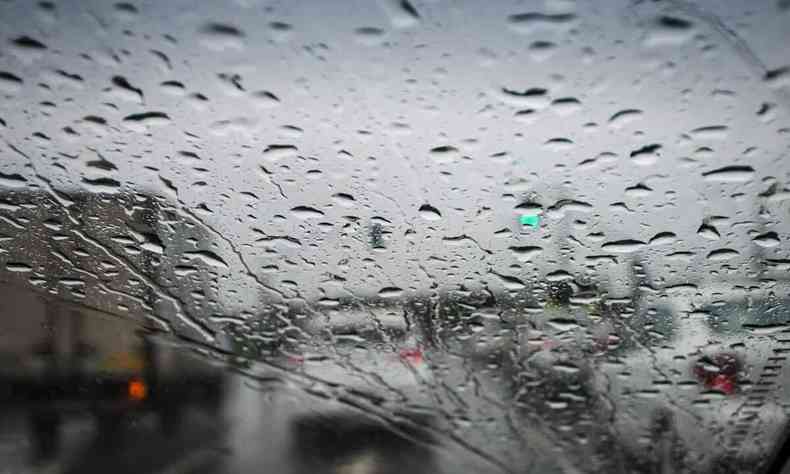 Vidro com pingos de chuva e carros no trânsito em BH