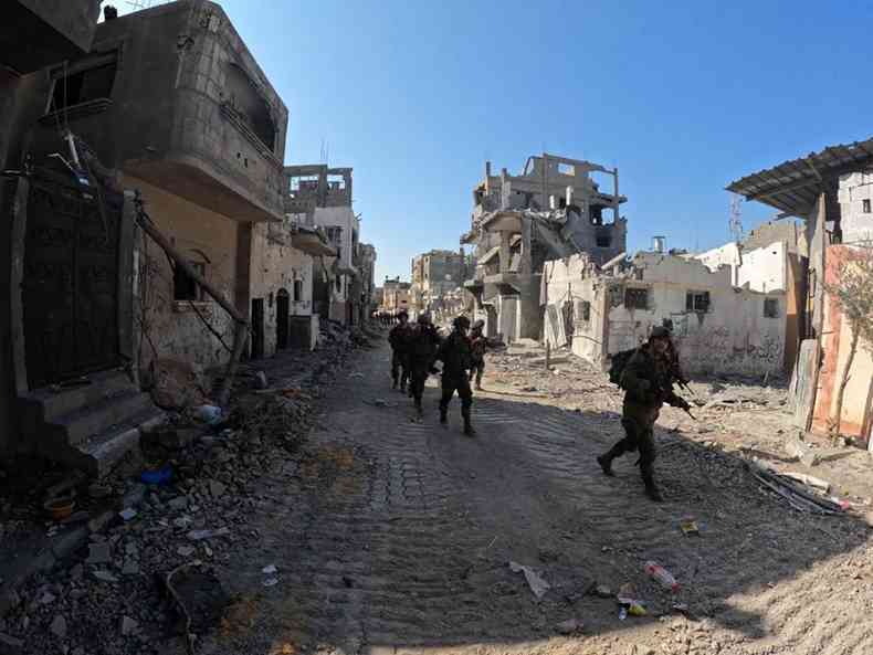 Soldados percorrem ruas entre runas de bombadeios em Gaza