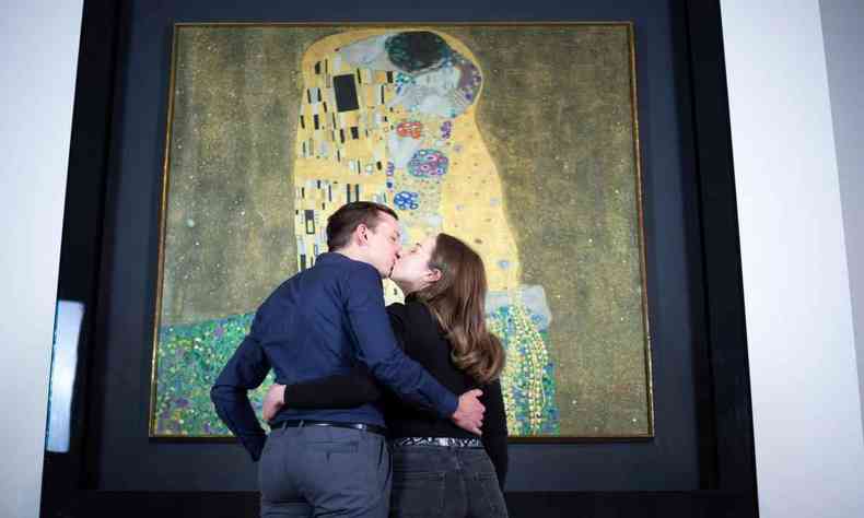 Casal se beija em frente ao quadro O beijo, de Klimt