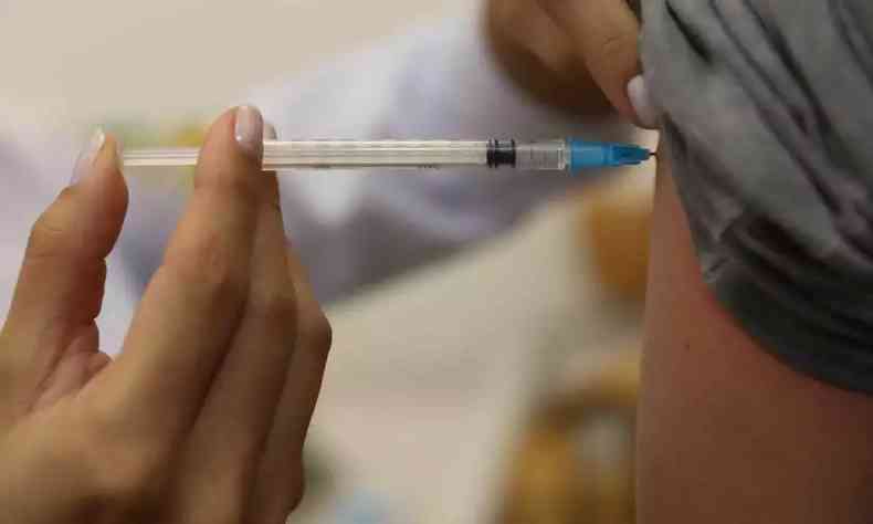 vacina sendo injetada em brao de adulto 