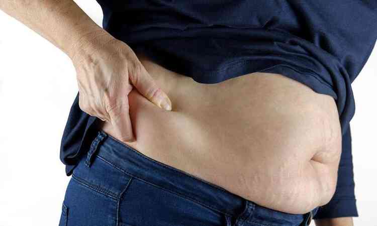mulher mostra excesso de gordura na cintura 
