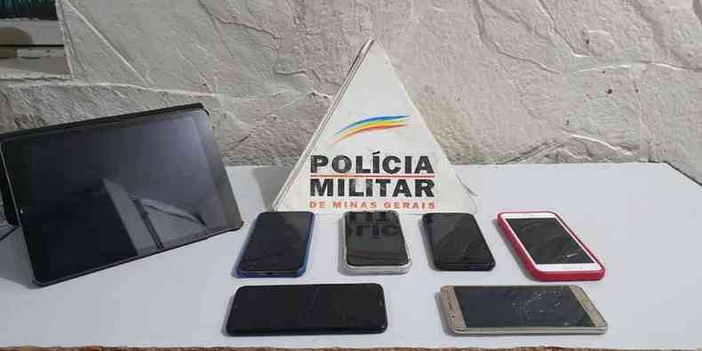 celulares em cima de uma mesa com o braso da Polcia Militar de MG 