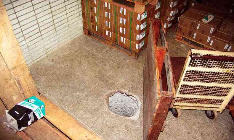 Biombo esconde buraco feito no cho de local com mveis de madeira e piso em cermica 