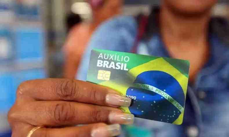 Cidado segurando carto auxilio brasil