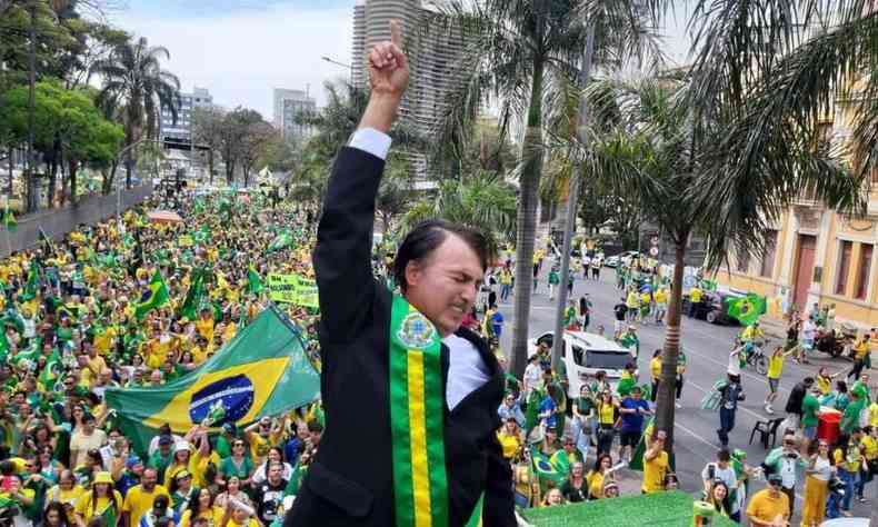 Apoiador vestido com a faixa do Brasil e um terno com o mesmo penteado de cabelo que Bolsonaro usa 