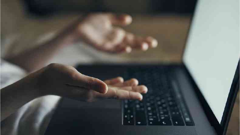 Mãos sobre o teclado de um laptop
