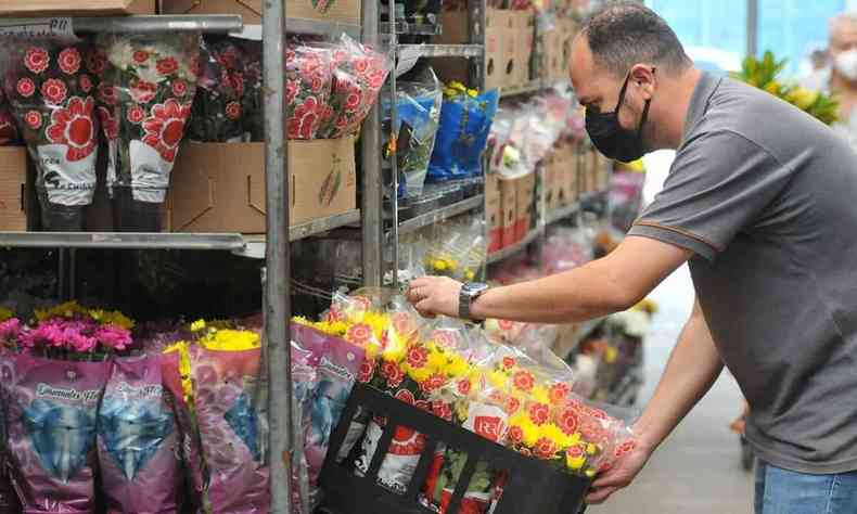 Ricardo Moreira Porto arruma banca em que expe flores