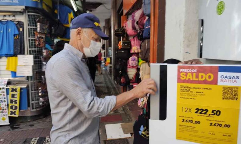 Caetano Silva, apesar de querer comprar a geleadeira, afirma estar 'desconfiado' com os preços(foto: Jair Amaral/EM/DA Press) Na foto, Caetano Silva observa preço da geladeira