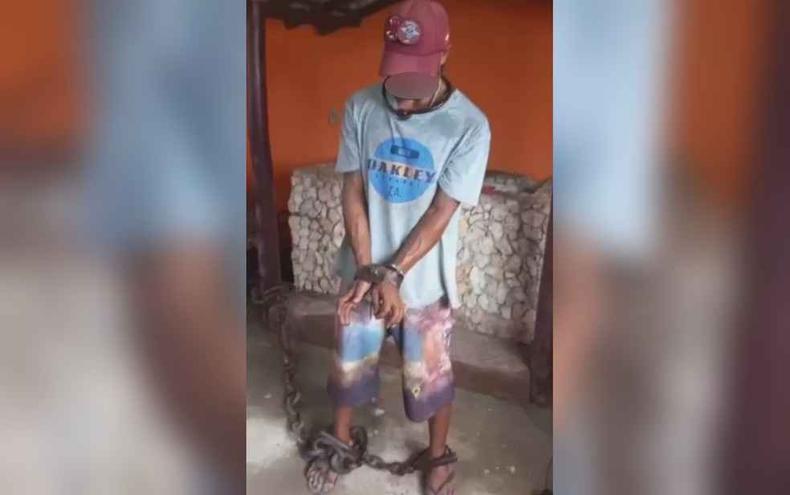 Homem foi filmado por médico acorrentado e algemado (foto: Reprodução/Polícia Civil ) Homem foi filmado por médico acorrentado e algemado