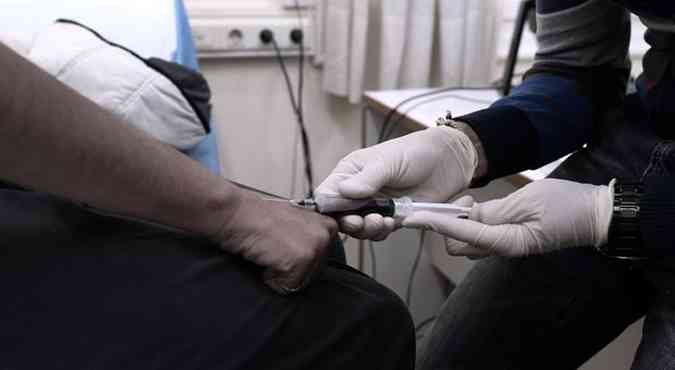Usurio de drogas tira sangue para teste de HIV antes de receber droga para consumir em clnica em Atenas, na Grcia. Os 