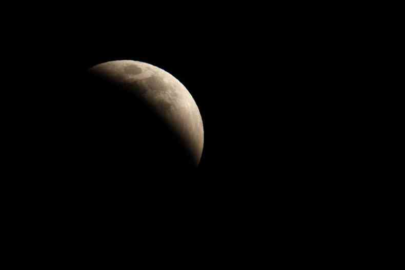 A lua praticamente encoberta vista de Huntington Beach, na Califrnia