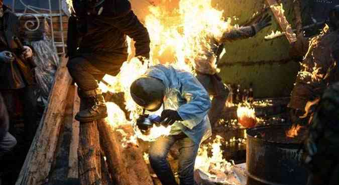 Manifestante  atingido por coquetel molotov em protestos na Ucrnia(foto: BULENT KILIC / AFP)
