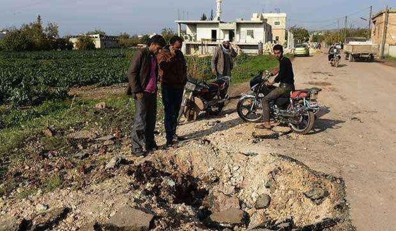 Moradores observam estragos causados por bomba na cidade de Atme, próxima à fronteira com a Turquia(foto: AFP PHOTO / FRANCISCO LEONG ) Moradores observam estragos causados por bomba na cidade de Atme, próxima à fronteira com a Turquia(foto: AFP PHOTO / FRANCISCO LEONG )