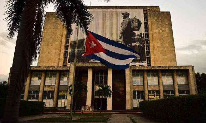 Fachada da biblioteca nacional cubana com a bandeira a meio mastro e uma foto do lder revolucionrio Fidel Castro na Praa da Revoluo, em Havana(foto: AFP / RONALDO SCHEMIDT )