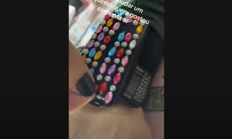 Mulher cola adesivos brilhantes na tornozeleira eletrnica 