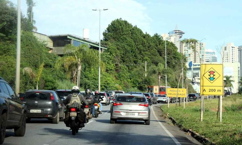 grande fluxo de trnsito no Belvedere, d para ver uma placa de semforo logo a frente 