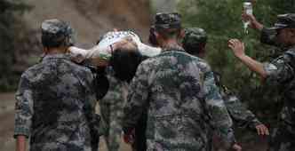 Equipe de resgate socorre mulher que se feriu durante o terremoto na China(foto: AFP PHOTO/STR CHINA OUT )