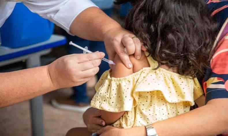 Crianas sendo vacinada por profissional de sade 