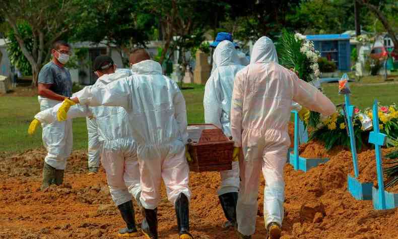 Coveiros carregam o caixo de uma vtima do COVID-19 no cemitrio Nossa Senhora Aparecida em Manaus, em meio  nova pandemia de coronavrus. (22/01/2021)(foto: Mrcio James/AFP)