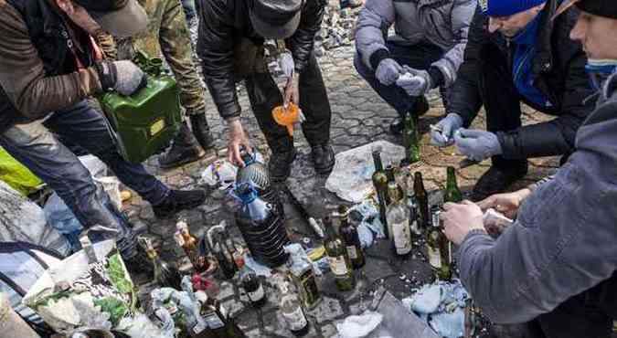 Manifestantes anti-governo produzem coquetis molotov no meio das ruas de Kiev(foto: SANDRO MADDALENA/AFP)