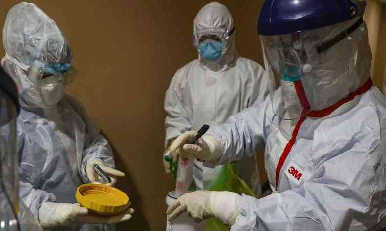 Equipe com amostras coletadas de pessoas que esto em quarentena sob suspeita de terem contrado coronavrus (foto: AFP)