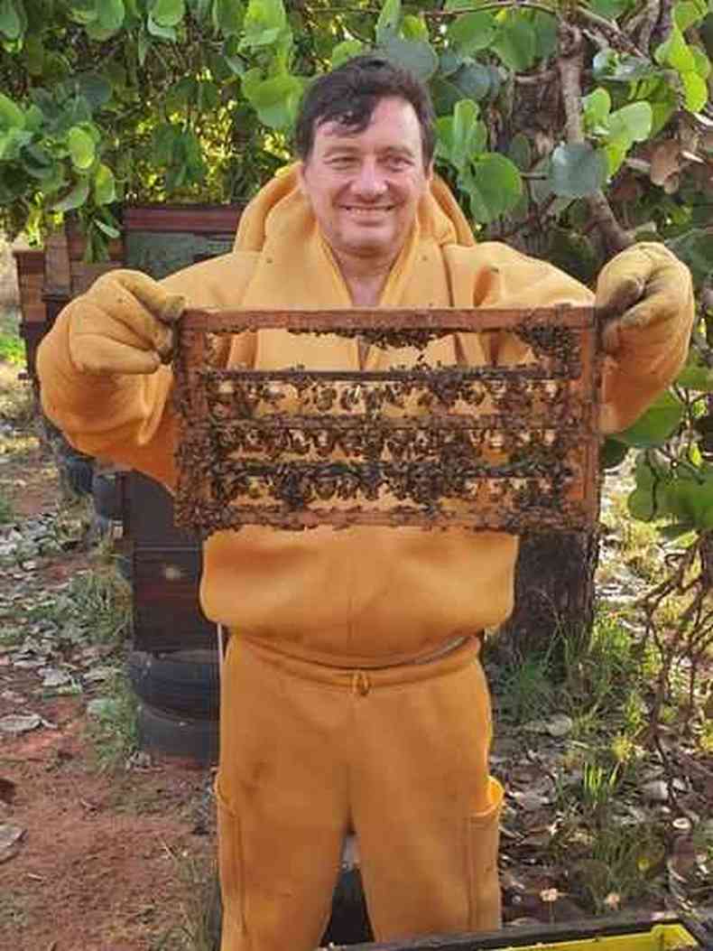 O apicultor Adriano Adames segurando tela com abelhas
