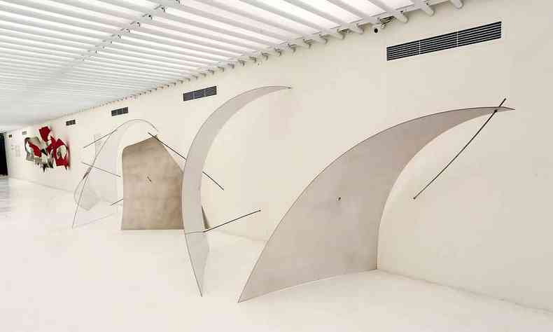 Escultura Arruaa, de Iole de Freitas, obtm impressionante leveza com placas de ao curvas presas  parede com barras semelhantes a parafuso 