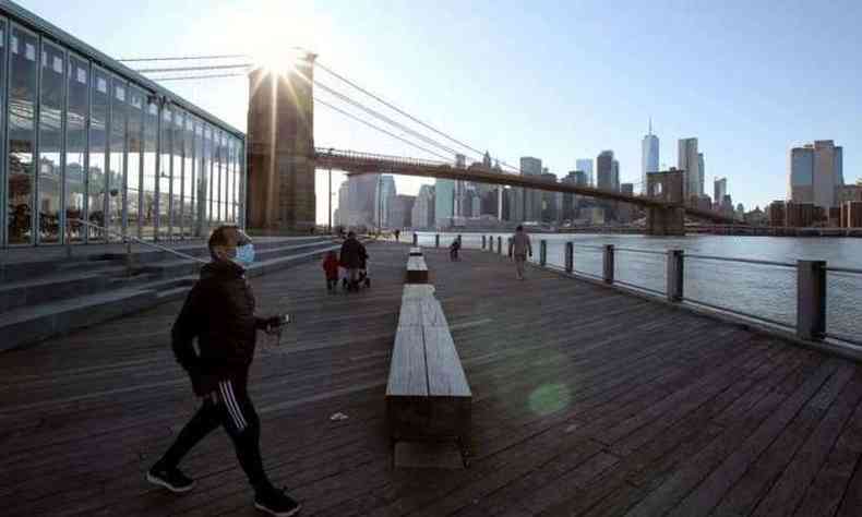 Pedestre usando uma mscara protetora caminha no cais no Brooklyn, em Nova York(foto: Justin Heiman /AFP )