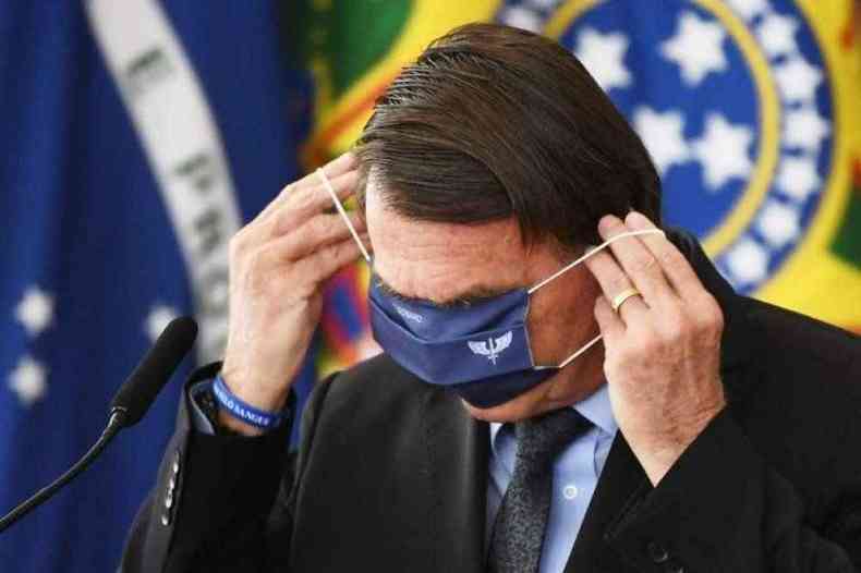 Presidente se complica ao colocar mscara de proteo(foto: Evaristo S/AFP)