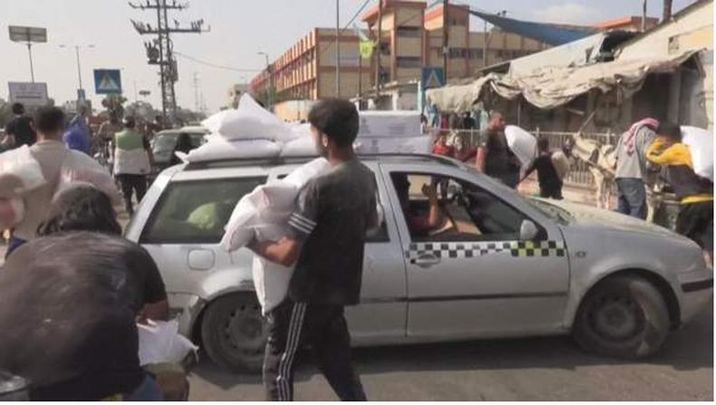 Civis em Gaza estão desesperados por ajuda humanitária, com agências de apoio afirmando que são necessárias centenas de caminhões para aliviar a crise(foto: AFP) Moradores carregando suprimentos em Gaza