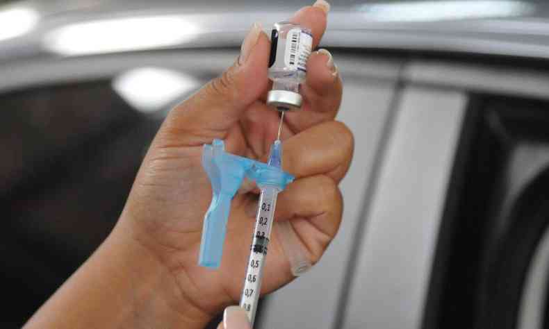 Enfermeira prepara vacina da Pfizer na seringa