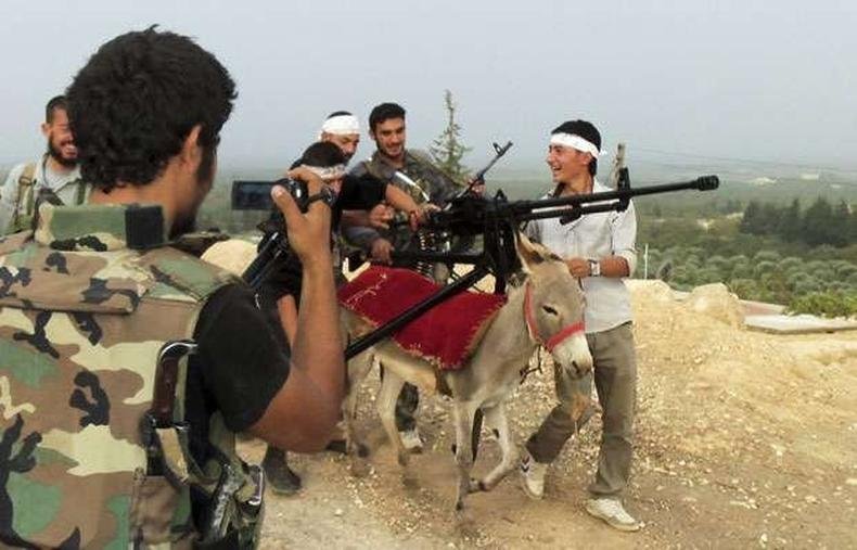 Soldados do Ex�rcito de Liberta��o s�rio carregam armas em burrico ap�s confronto com for�as fi�is ao presidente(foto: REUTERS/Redwan al-Homsi/Shaam News Network/Handout )