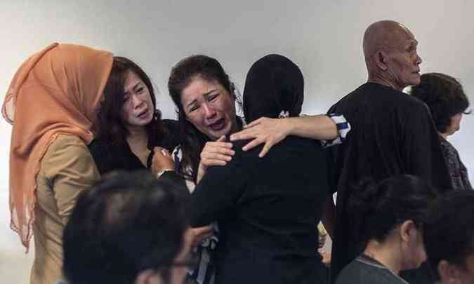 Familiares de passageiros que estavam no avio da AirAsia se renem no aeroporto de Surabaya(foto: Juni Kriswanto/AFP )