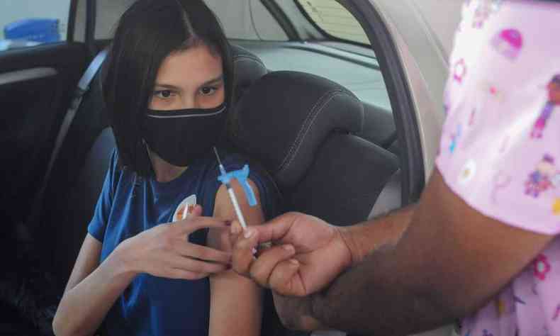 Maria Eduarda Noronha, de 13 anos, tomando a primeira dose da vacina 