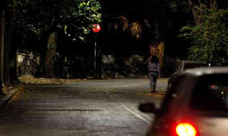 Pedestre anda em rua com pouca iluminao prximo  Praa da Liberdade, em Belo Horizonte