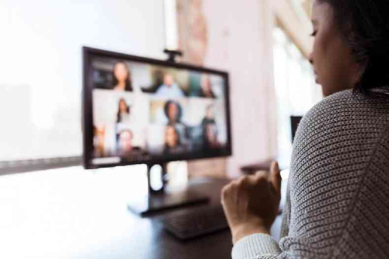 Mulher participa de reunião virtual no computador em casa
