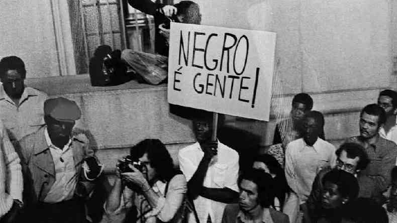 Manifestao do Movimento Negro Unificado, 1980. No centro da foto, manifestante com cartaz onde se l: 'Negro  gente'