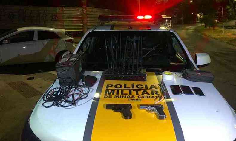 Armas e materiais apreendidos pela polcia na ao. Ao fundo, carro dos suspeitos, que tinha queixa de roubo(foto: PMRv/Divulgao)