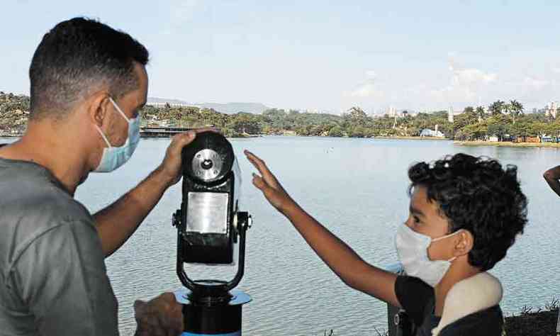 Mateus Frana e o filho Lucas posicionam o instrumento para mirar a orla da Lagoa da Pampulha: ' bem potente e com preciso', comentou o pai depois da experincia(foto: Leandro Couri/EM/D.A Press)