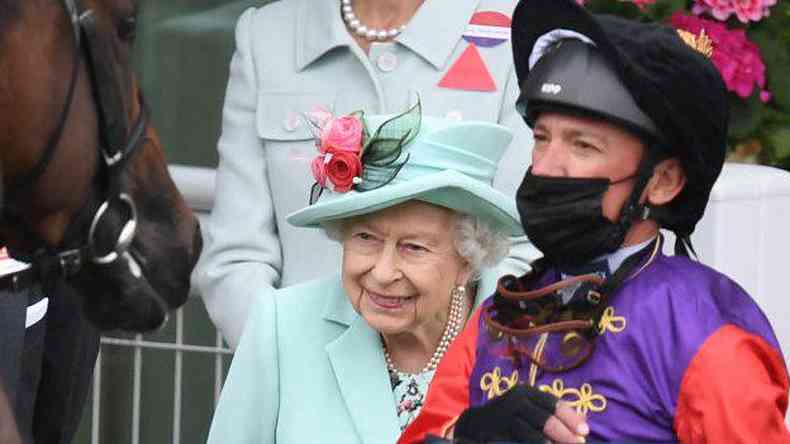 A rainha sorrindo ao lado do jquei Frankie Dettori