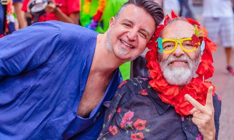 Wagner Tameirão e Marcelo Xavier, sentado na cadeira de rodas, sorriem para a câmera
