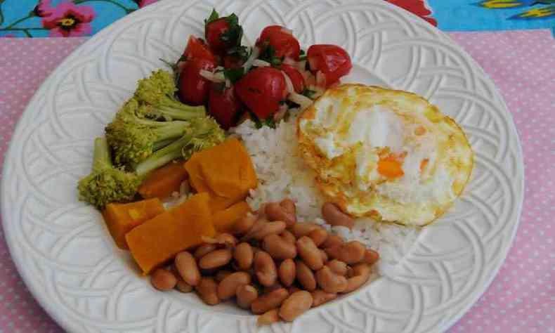 Prato de comida com arroz, feijo, salada e ovo