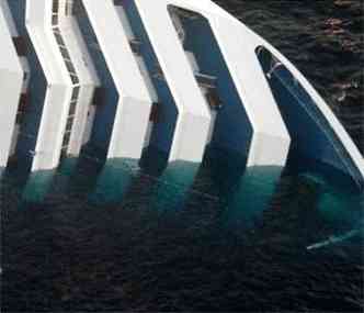 gua invade a embarcao que tomba no mar aps ter encalhado(foto: AFP)