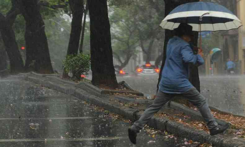 Imagem de um homem andando sob a chuva em Belo Horizonte