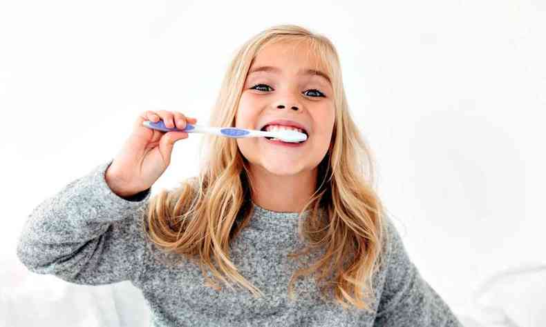 menina escovando os dentes