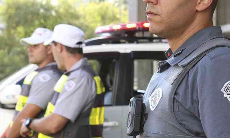 Policiais militares de so paulo com viatura ao fundo