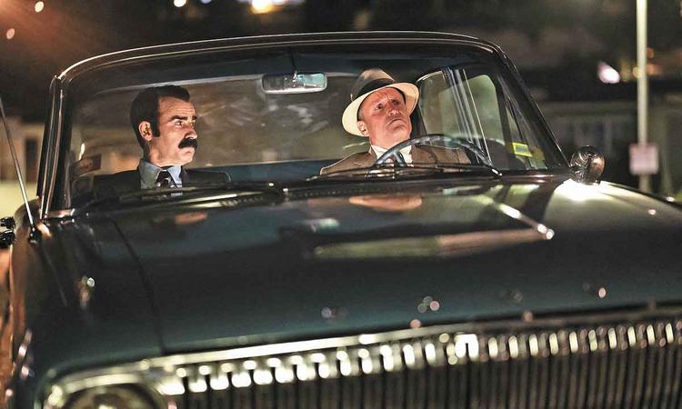 Os atores Woody Harrelson (E. Howard Hunt) e Justin Theroux (G. Gordon Liddy) sentados em carro, em cena de Os encanadores da Casa Branca