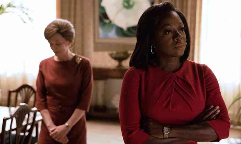 De vestido vermelho, a atriz Viola Davis est de braos cruzados e cara fechada, na srie The first lady. Ao fundo, v-se mulher loura de coque e vestido marrom