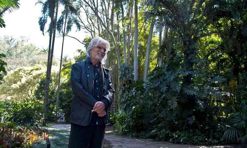 Bernardo Paz sorri, tendo ao fundo árvores e plantas do Instituto Inhotim